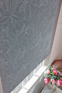 A close-up image of a window shade with flower patterns.